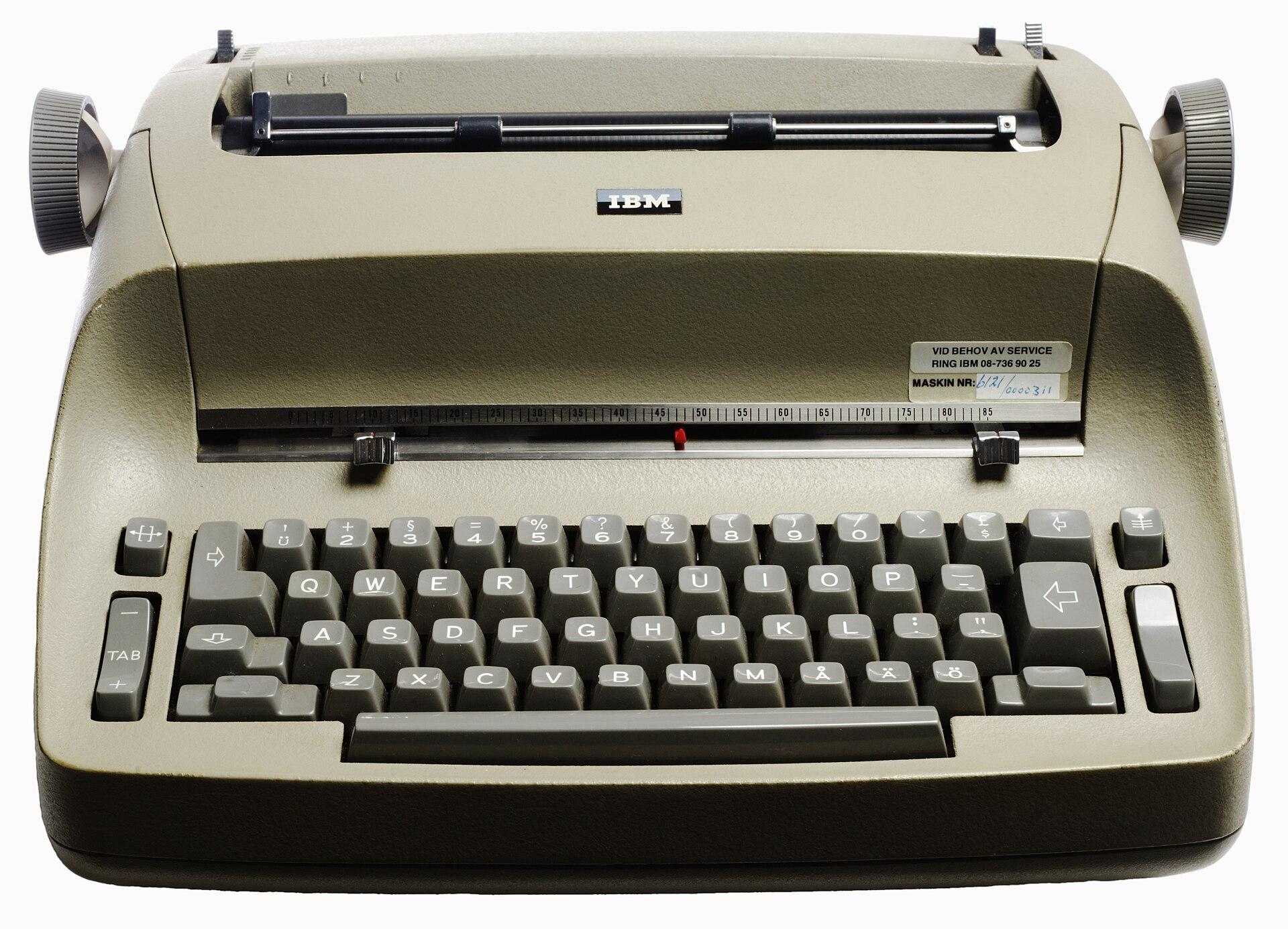 IBM Selectric electric typewriter with its dust cover, ribbon cassette and eraser accessories