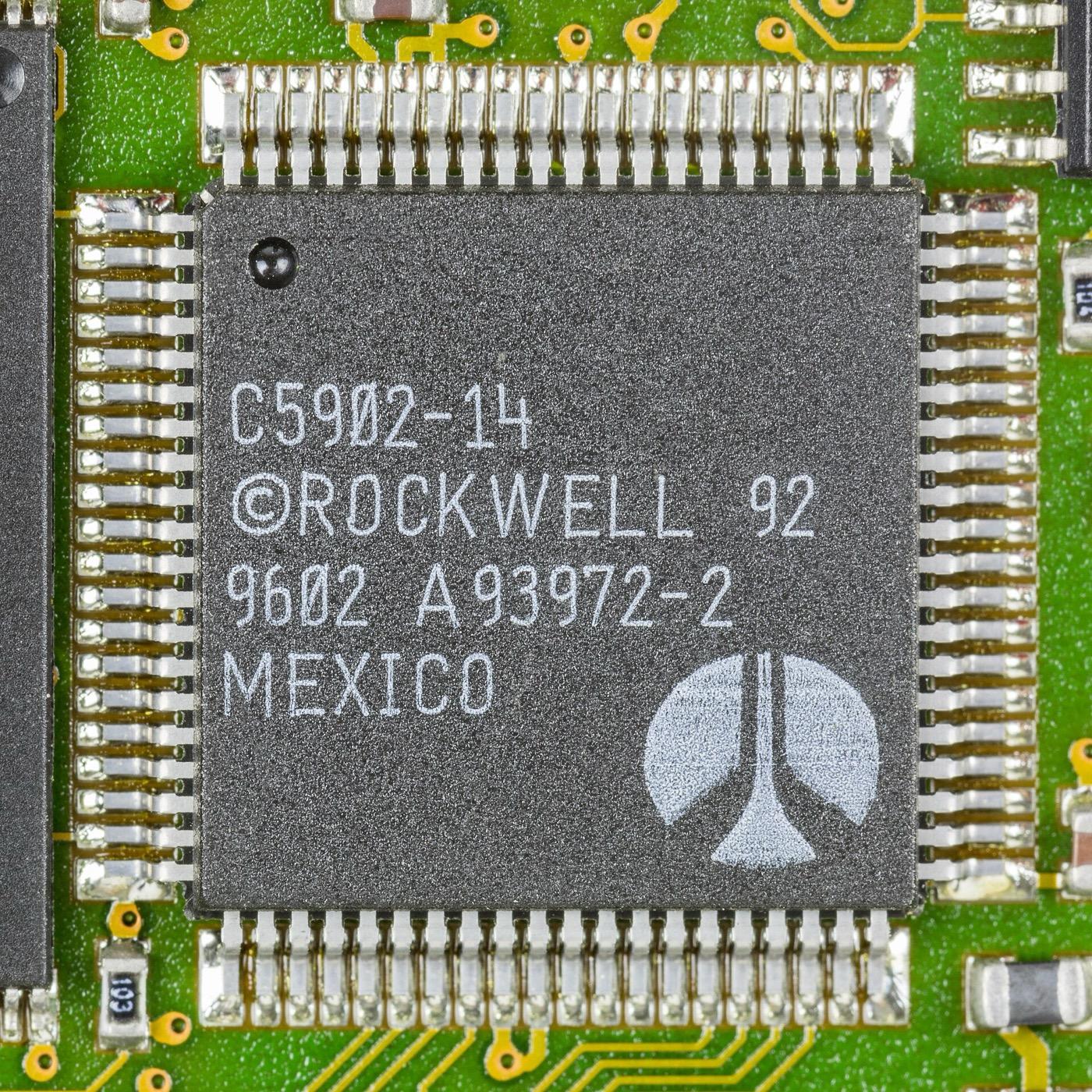 Macro photograph of a square surface-mounted controller chip on a green circuit board, marked C5902-14, ROCKWELL 92, 9602, A93972-2, MEXICO