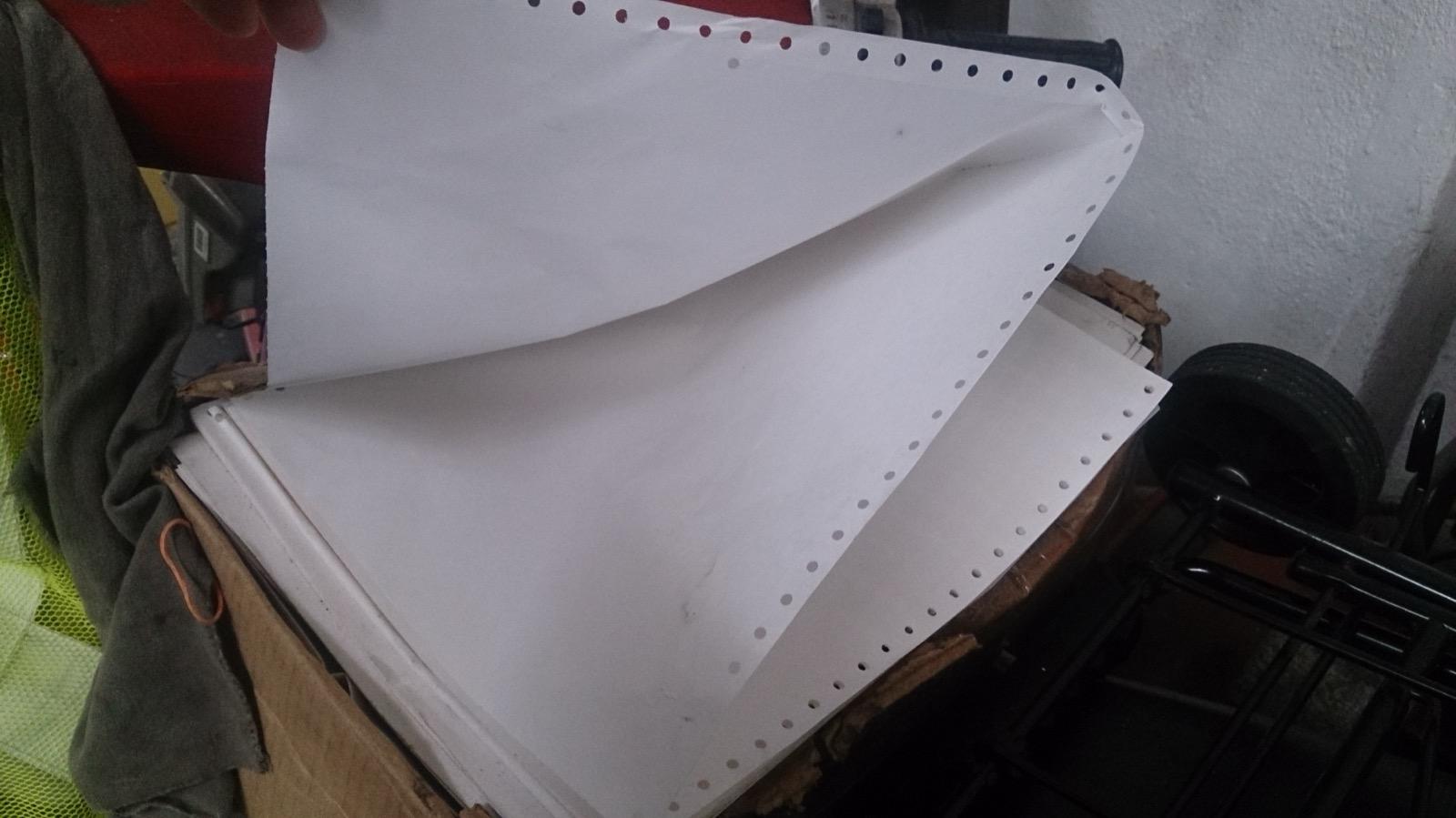 Folded sheet of continuous-form computer paper with perforated sprocket strips along both edges