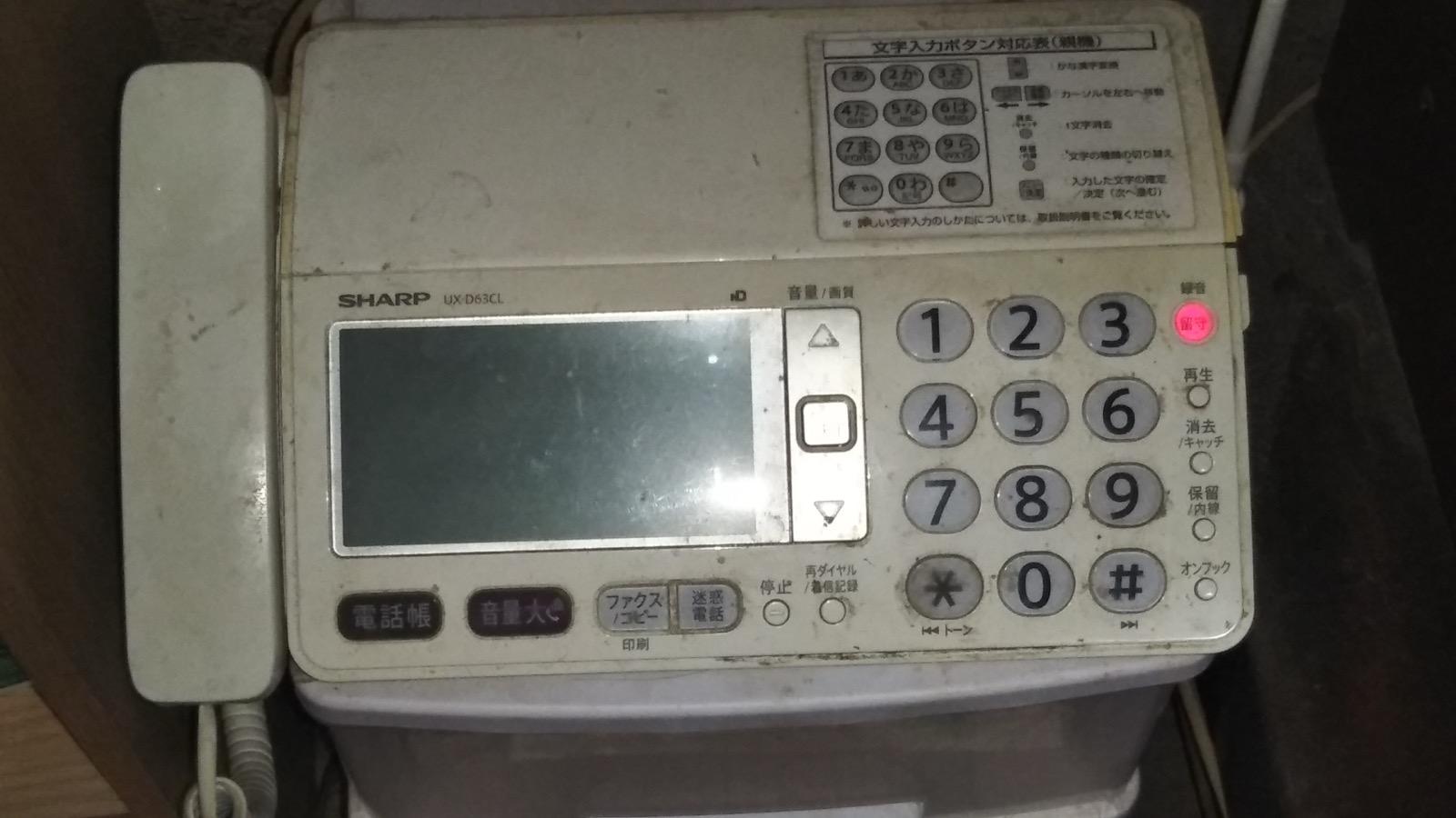 A Sharp UX-D63CL desktop fax machine with a document feeder, handset, and numeric keypad