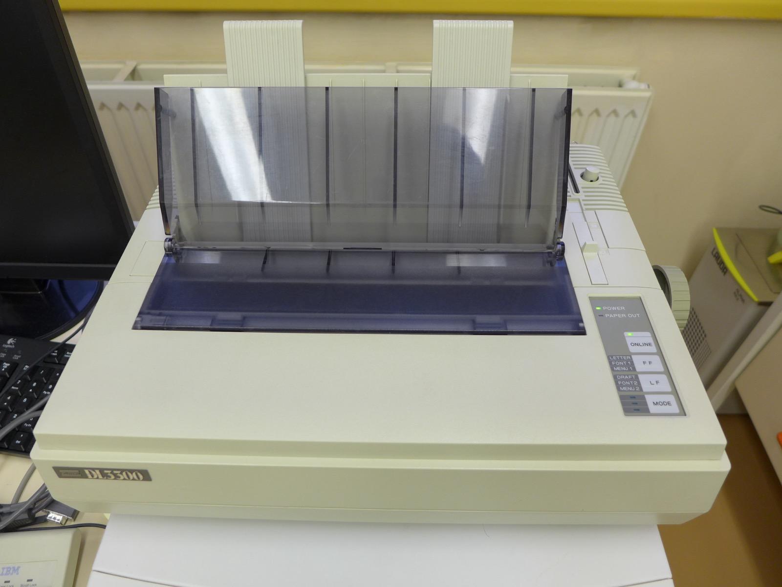 A Fujitsu DL3300 dot matrix printer with continuous tractor-feed paper loaded